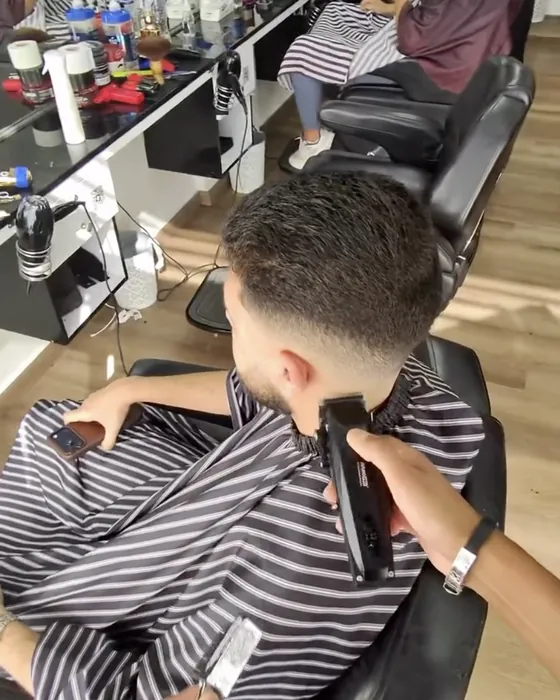 Coupe à la tondeuse en cours dans le salon Mr Cut